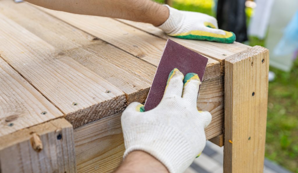 Tools for sanding wood Carpenter sanding wooden plank on table closeup Sanding wood with sandpaper - Wurth Louis and Company Tools for sanding wood Carpenter sanding wooden plank on table closeup Sanding wood with sandpaper
