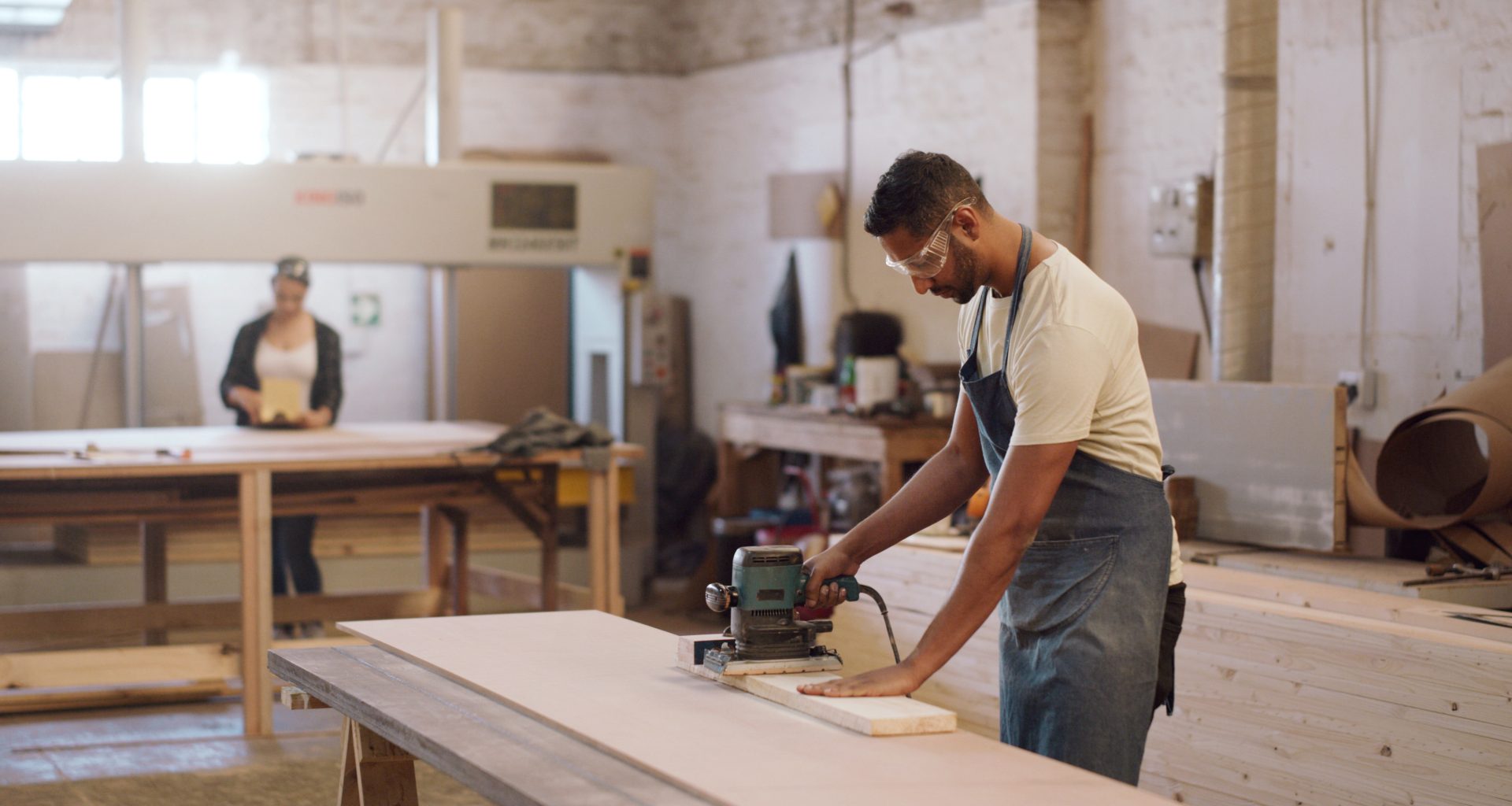 Carpenter man and sanding machine in workshop with woodwork project furniture production and craft Artisan person and manufacturing with glasses electric tools or carpentry equipment for timber