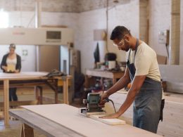 Carpenter man and sanding machine in workshop with woodwork project furniture production and craft Artisan person and manufacturing with glasses electric tools or carpentry equipment for timber